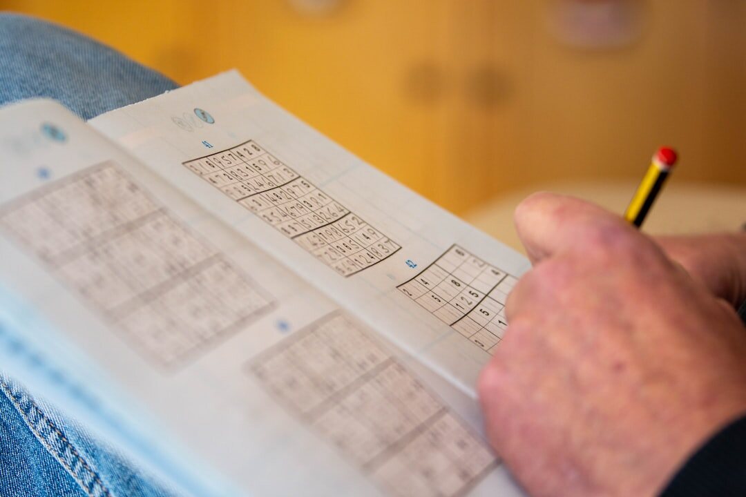 Person writing notes in a journal at a wooden desk